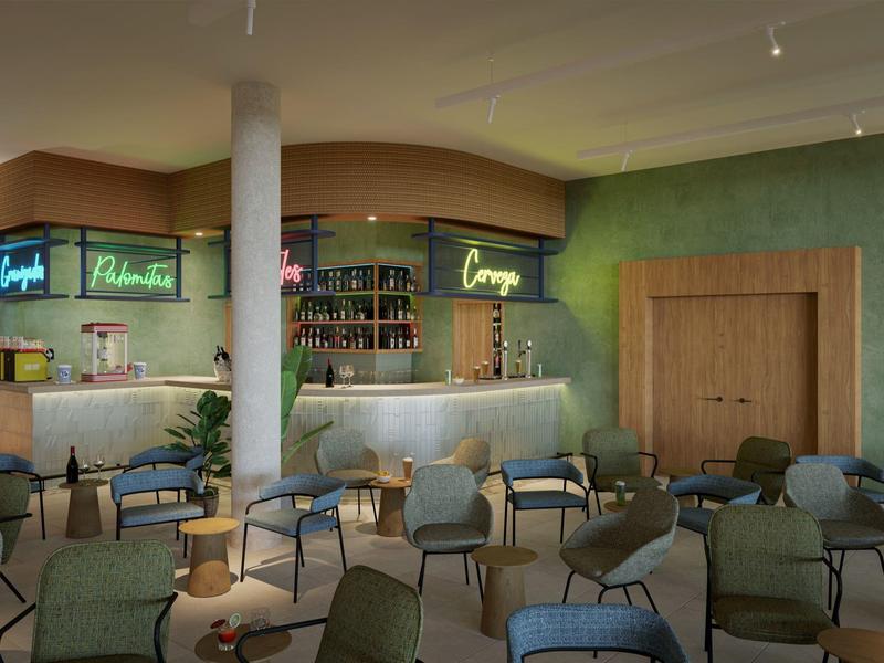 Cozy hotel bar with green walls, wooden door, and various chairs around small tables.