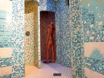 Douches avec carrelage mosaïque bleu et blanc dans un espace bien-être.