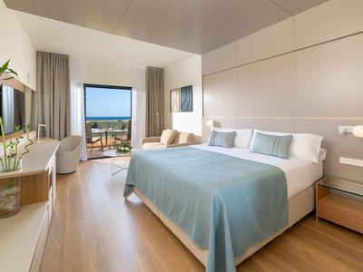 Chambre d'hôtel moderne avec lit double, balcon et vue sur le paysage.