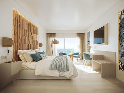 Modern gestaltetes Hotelzimmer mit großem Bett, Meerblick und hellem Holzmobiliar.