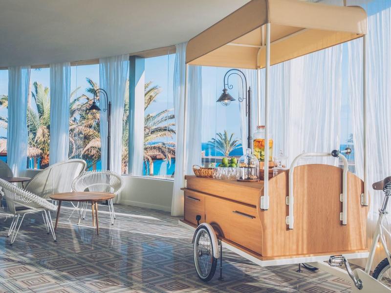 Carretto moderno in una stanza luminosa con grandi finestre e vista su palme