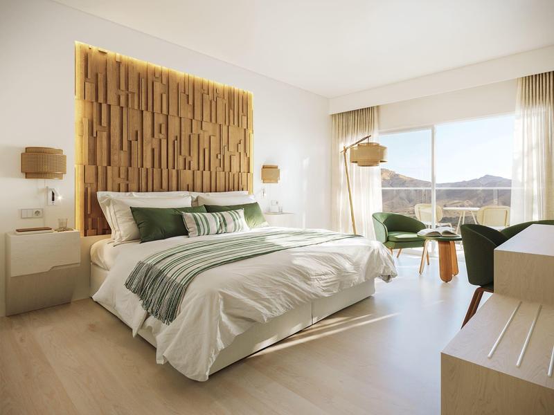 Camera d'hotel moderna con letto grande, parete in legno e area salotto vicino alla finestra con vista sulle montagne.