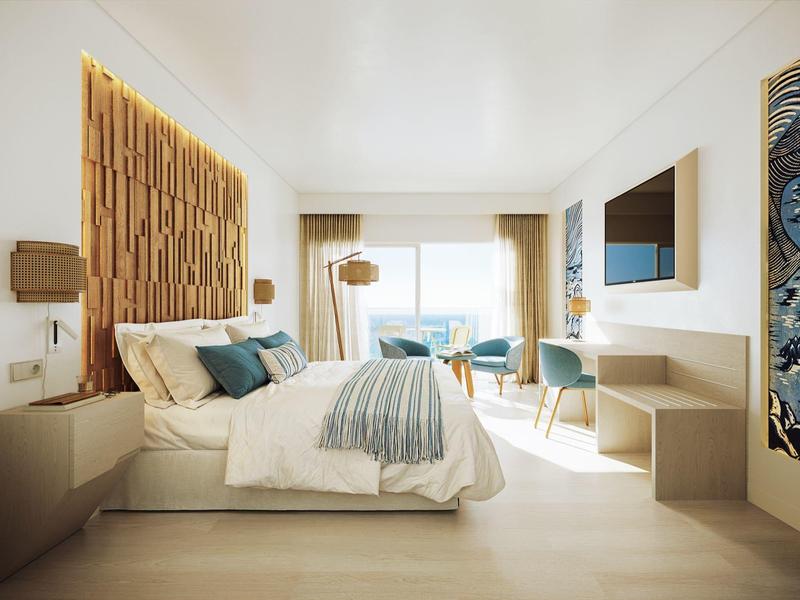 Camera d'hotel moderna con letto grande, vista balcone e interni in legno chiaro.