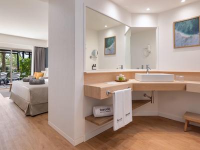 Salle de bain moderne ouverte sur une chambre avec terrasse et vue sur jardin.