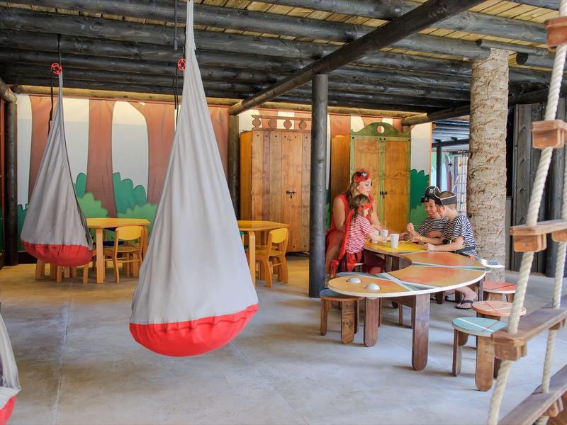 Espace moderne avec chaises suspendues et personnes assises à une table en bois.