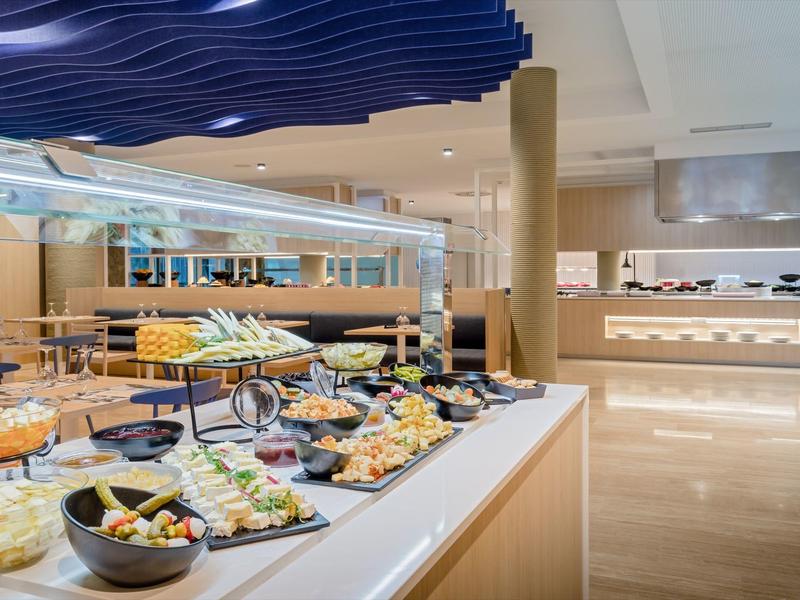 Buffet élégant avec une variété de plats sur un comptoir blanc dans un hôtel moderne.