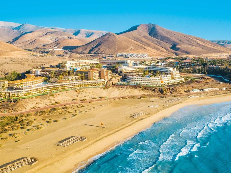 Kurort nadmorski przy suchych wzgórzach z złotym piaskiem i niebieską wodą