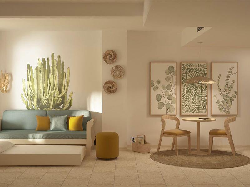 Jasny salon z sofą, kaktusem, okrągłymi dywanami i minimalistycznym wystrojem.