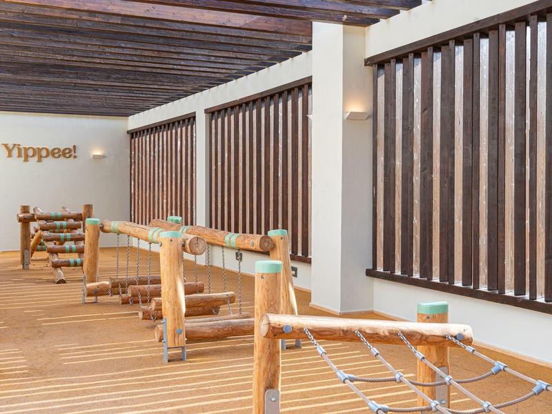 Nowoczesna przestrzeń zewnętrzna z drewnianymi siedzeniami i siatkami w relaksującej atmosferze.