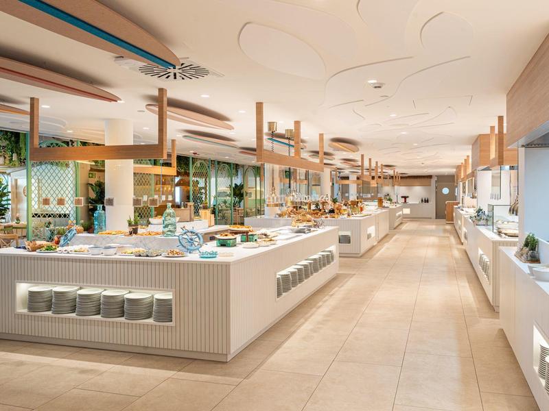 Jasna, nowoczesna restauracja bufetowa z drewnianą dekoracją i szerokim wyborem jedzenia.