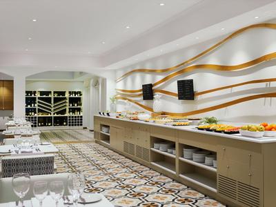 Modern dining room with tables, decorative wall art, and buffet area in a hotel.