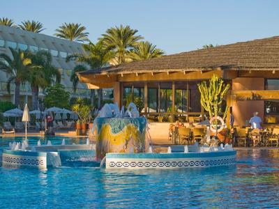 Ristorante dell'hotel con piscina e ombrelloni sotto un cielo sereno