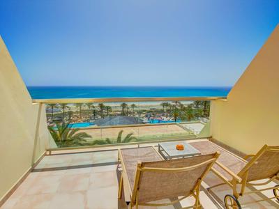 Balcone con due sedie a sdraio e vista mare in un hotel.