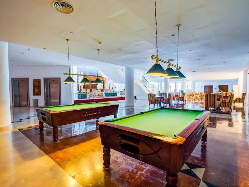 Interno con due tavoli da biliardo e posti a sedere in uno spazio luminoso e aperto.
