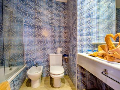 Koupelna s toaletou, bidetem, vanou a umyvadlem s pečlivě složenými ručníky.