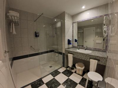 Modern bathroom with large walk-in shower and black-and-white checkered floor tiles.