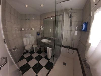 Modern bathroom with black and white checkered floor, shower, and bathtub