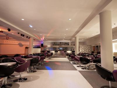 Modern hotel lounge area with comfortable chairs and subdued lighting.
