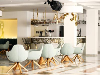 Moderne Lounge mit hellblauen Sesseln, hölzernen Beinen und hellem Marmorboden.