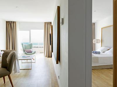Helle moderne Wohnung mit Wohn- und Schlafzimmer, Holzfußboden, großen Fenstern und Vorhängen.