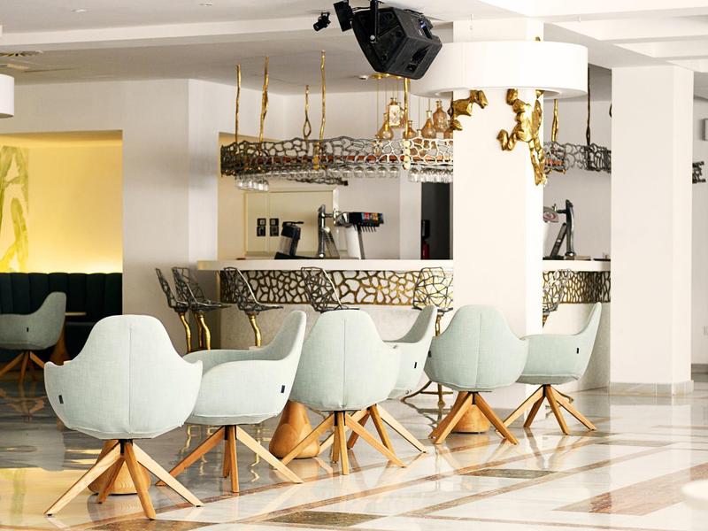 Moderna hall dell'hotel con eleganti sedie azzurre e pavimento in marmo.