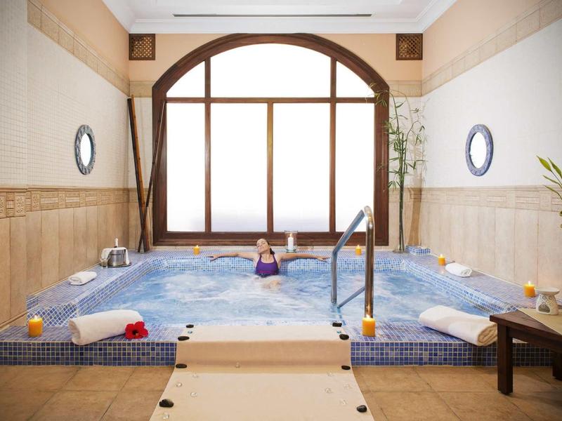 Vnitřní vířivka v relaxačním prostoru s svíčkami a dekoracemi