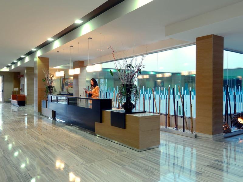 Moderne hotelreceptie met gepolijste marmeren vloer en stijlvolle decoraties.