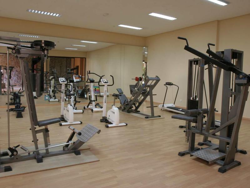 Una palestra con diverse macchine per esercizi su pavimento in legno.