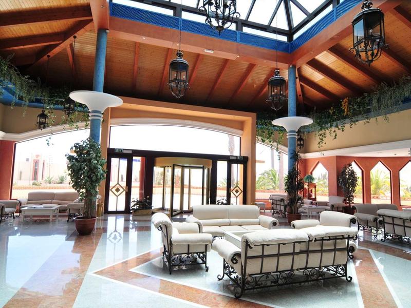 Ampia e luminosa hall dell'hotel con comodi posti a sedere e soffitto in vetro.