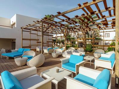 Moderner Außenbereich mit Holzboden, blauen Polstern und Pergola mit Pflanzen an der Decke.