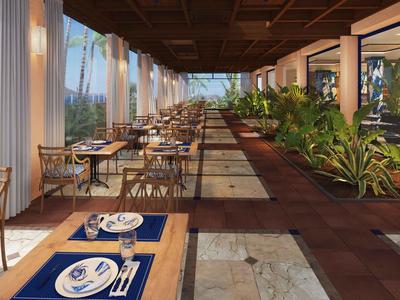 Overdekt buitenterras met houten tafels, stoelen en planten langs een betegelde vloer.