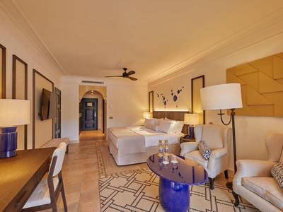 Gezellige hotelkamer met bed, zithoek, bureau en warme verlichting.