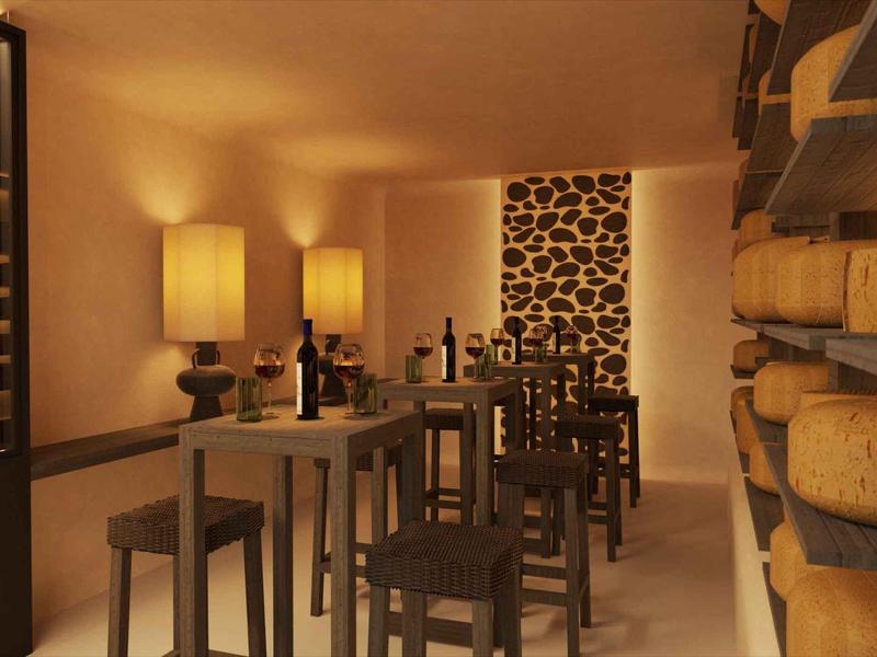 Gezellige wijnkelder met zacht licht, houten tafels, krukken en schappen vol kaas.