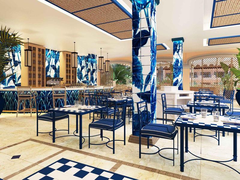 Modern overdekte eetruimte met blauw-witte inrichting, tafels, stoelen en groene planten.