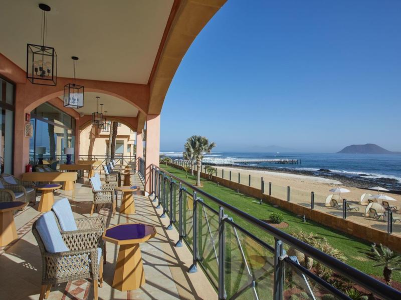 Balkon zithoek met uitzicht op de oceaan en het strand op een zonnige dag