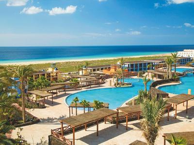 Baseny i tarasy w kurorcie nad morzem z niebieskim niebem.