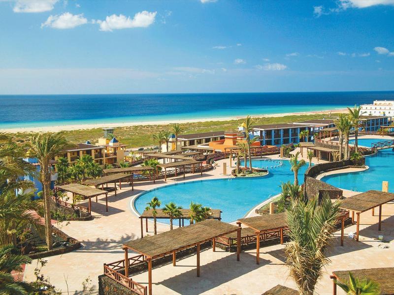 Baseny i tarasy w kurorcie nad morzem z niebieskim niebem.