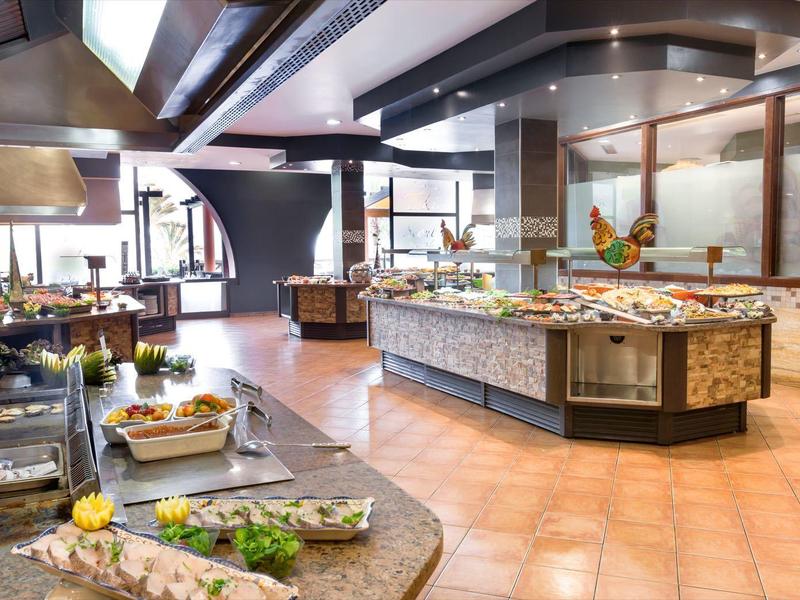 Elegancki bufet z różnorodnymi potrawami w przestronnej, jasnej restauracji.