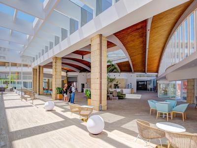 Ampia hall d'hotel moderna e luminosa con soffitti in legno e posti a sedere