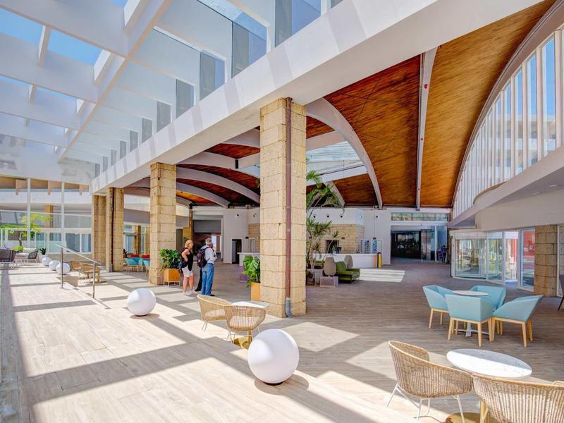 Ampia hall d'hotel moderna e luminosa con soffitti in legno e posti a sedere