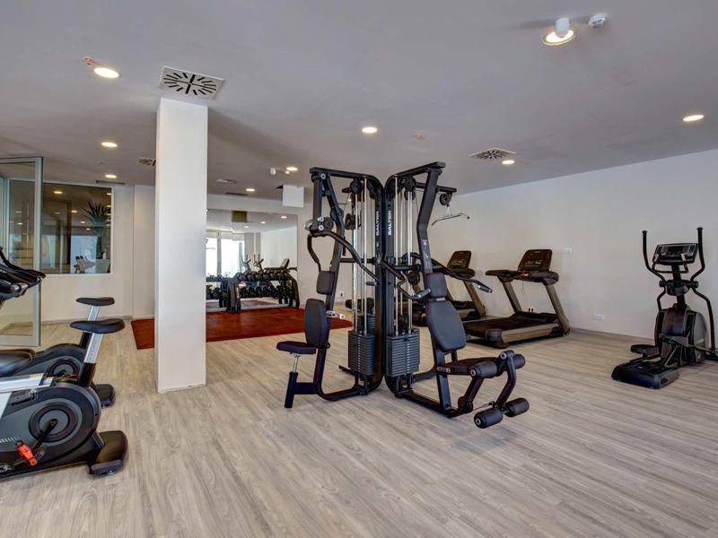 Palestra moderna con attrezzi da allenamento e pavimenti in legno chiaro in un hotel.