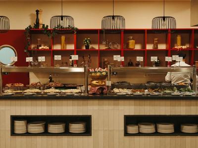 Bufet z różnymi potrawami i szefem kuchni w restauracji hotelowej.