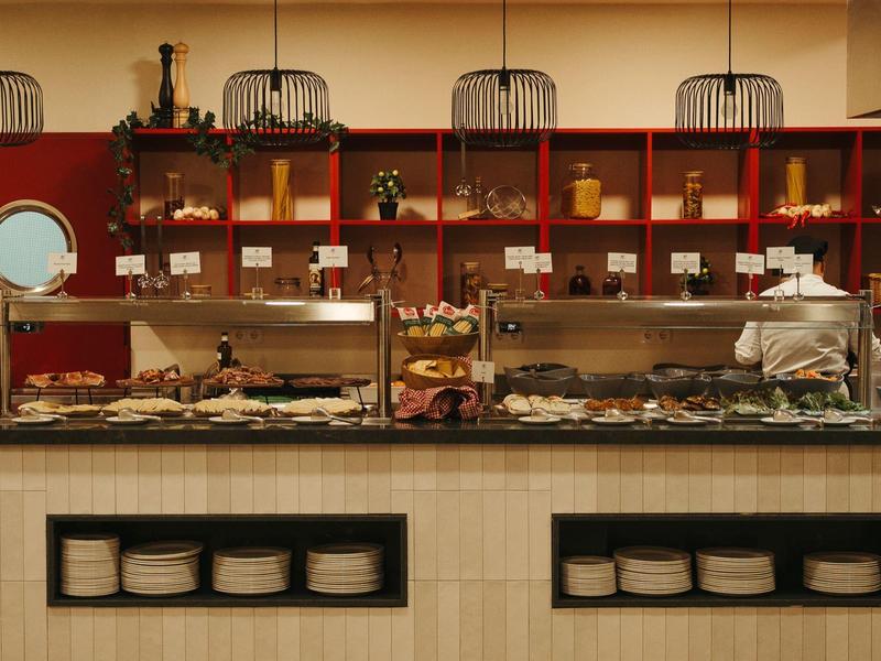 Bufet z różnymi potrawami i szefem kuchni w restauracji hotelowej.