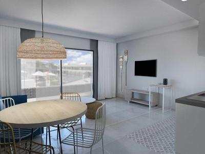 Espace de vie moderne avec coin repas et kitchenette, pièce lumineuse avec balcon et vue sur la montagne