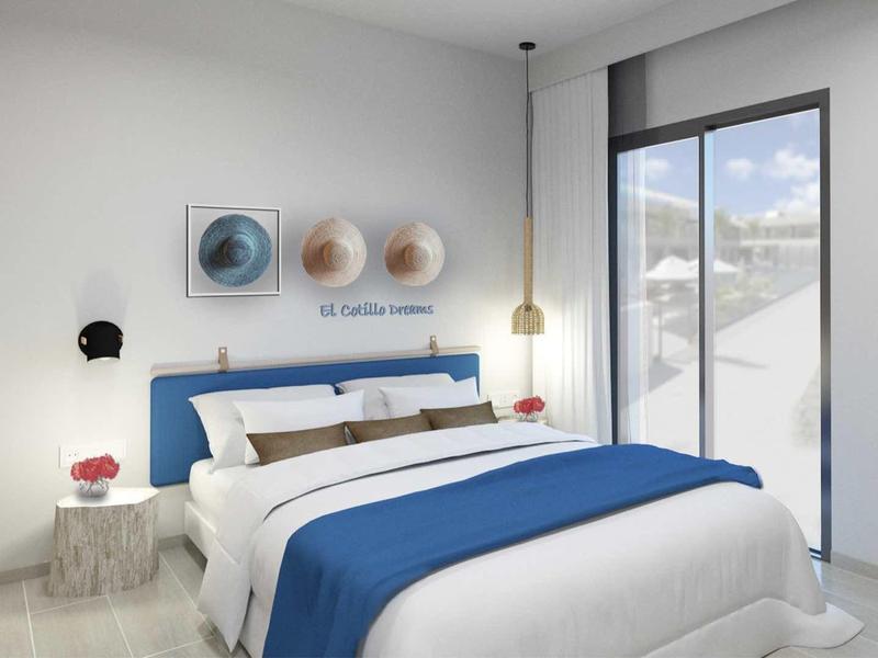 Chambre moderne avec lit double, accents bleus et grande fenêtre avec vue.