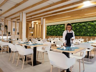 Restaurante moderno y luminoso de hotel con techo de madera, sillas blancas y decoración de pared verde.