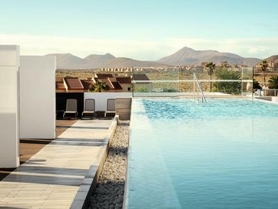 Piscine moderne avec vue sur les montagnes, terrasse et espace de détente extérieur