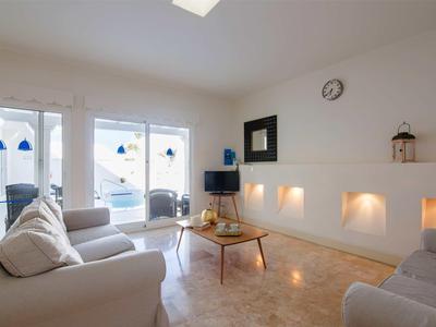 Bright living room with cozy sofas, large window, and modern fireplace lighting.