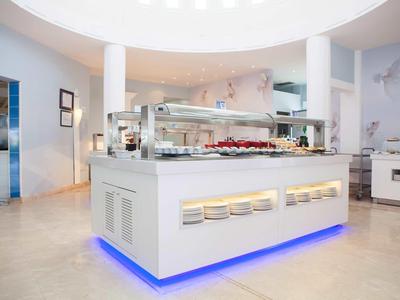 Modern and clean buffet area in a hotel restaurant with indirect blue lighting.