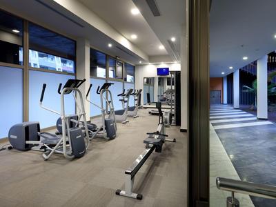 Gimnasio moderno con varias máquinas y vista al exterior.